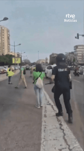 Un polic�a empuja a una manifestante por la espalda tir�ndola al suelo.